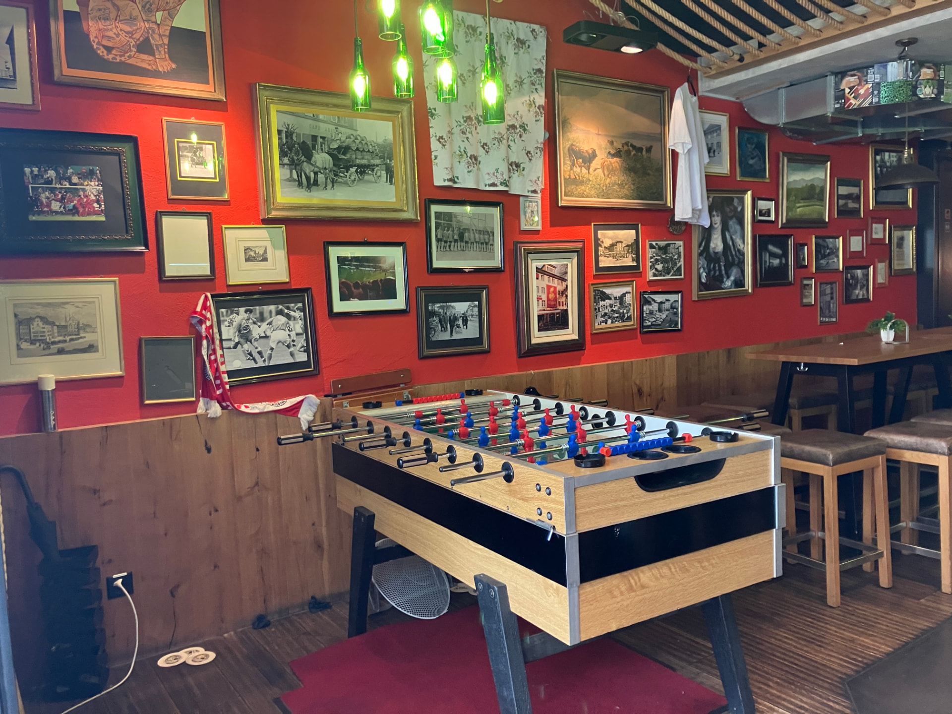 Tischfussballkasten vor der roten Wand voller Vintage-Bilder